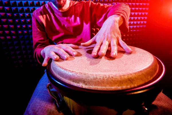Genç adam djembe ses kayıt stüdyosu içinde oynamaya. Afrika davul