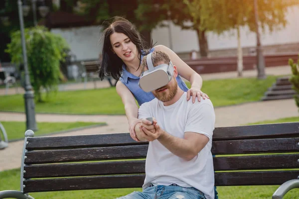 Genç çift sanal gerçeklik gözlükle sokakta bir oyun oynuyor. VR kulaklık.