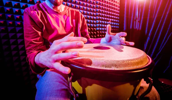 Genç adam djembe ses kayıt stüdyosu içinde oynamaya. Afrika davul