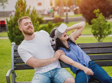 Genç çift sanal gerçeklik gözlükle sokakta bir oyun oynuyor. VR kulaklık.