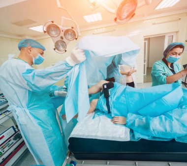 Artroskop ameliyatı. Modern artroskopik aletlerle ameliyathanede takım çalışması yapan ortopedik cerrahlar. Diz ameliyatı. Hastane geçmişi