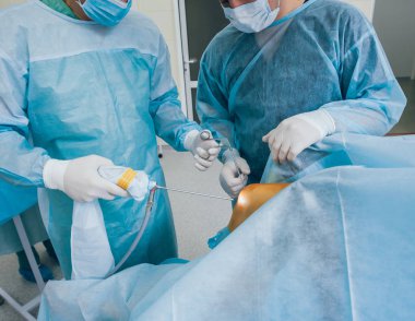 Artroskop ameliyatı. Modern artroskopik aletlerle ameliyathanede takım çalışması yapan ortopedik cerrahlar. Diz ameliyatı. Hastane geçmişi