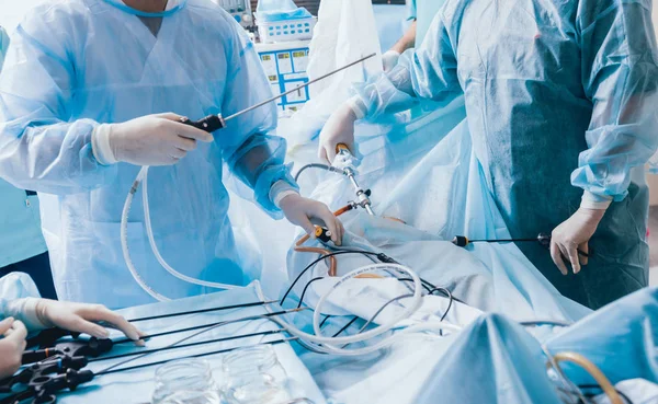 使用腹腔镜设备进行妇科手术的过程 在手术室的外科医生小组与手术设备 — 图库照片