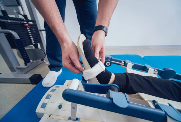 Patient on CPM (continuous passive range of motion) machines. Device to provide anatomically correct motion to both the ankle and subtalar joints. Foot\'s rehabilitation after injured