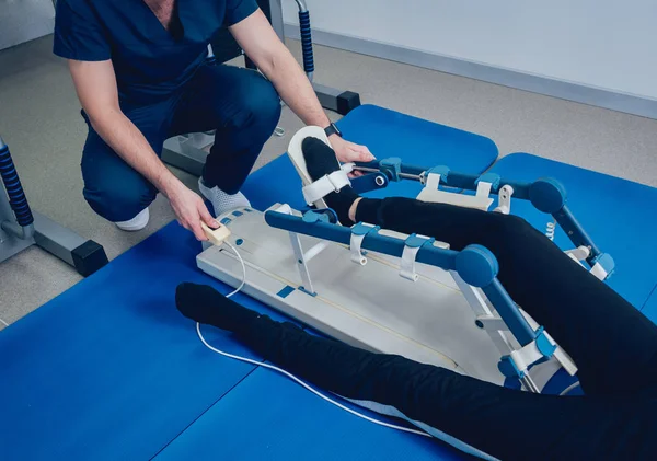 Patient on CPM (continuous passive range of motion) machines. Device to provide anatomically correct motion to both the ankle and subtalar joints. Foot\'s rehabilitation after injured