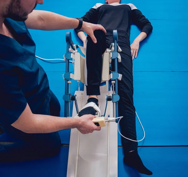 Patient on CPM (continuous passive range of motion) machines. Device to provide anatomically correct motion to both the ankle and subtalar joints. Foot\'s rehabilitation after injured