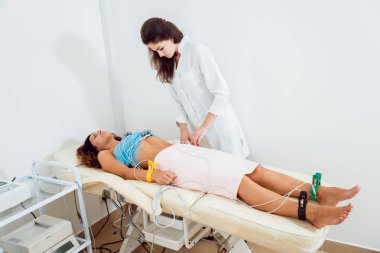 Klinikte hastaya kardiyogram testi yapan elektrokardiyogram ekipmanı olan doktor. Teşhis, sağlık, tıbbi hizmet