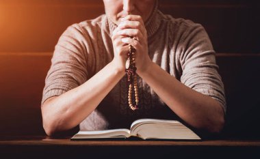 Kilisede dua Hıristiyan kadın. El geçti ve İncil'de ahşap masa üzerinde. Arka plan