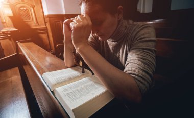 Kilisede dua Hıristiyan kadın. El geçti ve İncil'de ahşap masa üzerinde. Arka plan