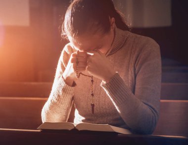 Kilisede dua Hıristiyan kadın. El geçti ve İncil'de ahşap masa üzerinde. Arka plan
