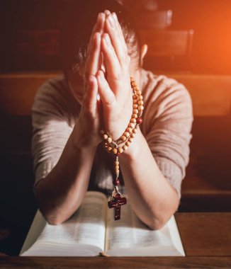 Kilisede dua Hıristiyan kadın. El geçti ve İncil'de ahşap masa üzerinde. Arka plan