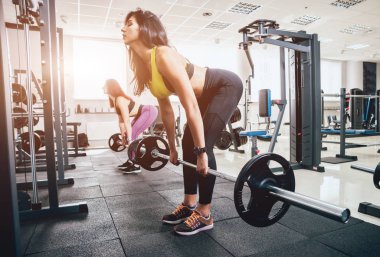 Güzel atletik genç kadın yapma egzersiz jimnastik salonu. Kas vücut olan kadın. Fitness kavramı.