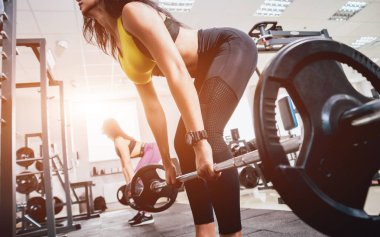 Spor salonunda egzersiz yapan güzel bir genç bayan. Kaslı vücutlu genç bir kadın. Fitness konsepti.