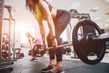 Spor salonunda egzersiz yapan güzel bir genç bayan. Kaslı vücutlu genç bir kadın. Fitness konsepti.