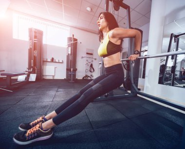 Spor salonunda egzersiz yapan güzel bir genç bayan. Kaslı vücutlu genç bir kadın. Fitness konsepti.