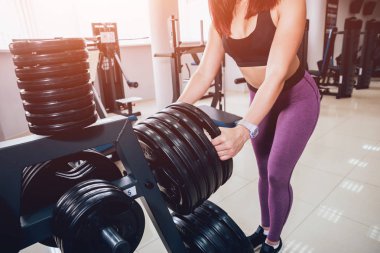 Spor salonunda egzersiz yapan güzel bir genç bayan. Kaslı vücutlu genç bir kadın. Fitness konsepti.