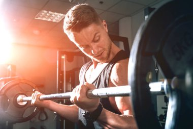 Halterle çalışan yakışıklı kaslı adam.