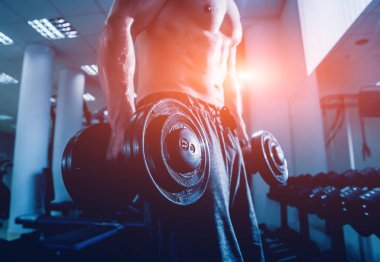 Yakışıklı kaslı adam dumbell ile çalışma dışarı. Fitness kavramı.