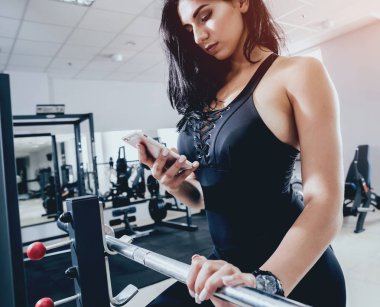 Spor salonunda egzersiz yapan güzel bir genç bayan. Kaslı vücutlu genç bir kadın. Fitness konsepti.