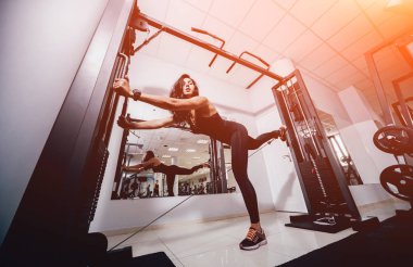 Spor salonunda egzersiz yapan güzel bir genç bayan. Kaslı vücutlu genç bir kadın. Fitness konsepti.