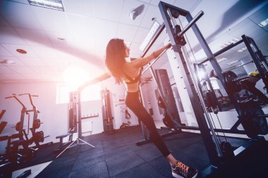 Spor salonunda egzersiz yapan güzel bir genç bayan. Kaslı vücutlu genç bir kadın. Fitness konsepti.