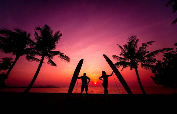 Silhouette Von Surfern Paar Mit Langen Surfbrettern Bei Sonnenuntergang Tropischen — Stockfoto