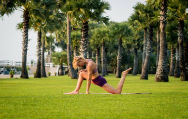 Güzel ve genç birbayan practic yoga sahilde. Sabah egzersiz. Avuç içi arka plan
