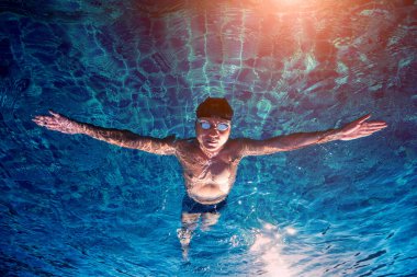Yüzme havuzunda yüzen genç sporcu, aktif spor konsepti  