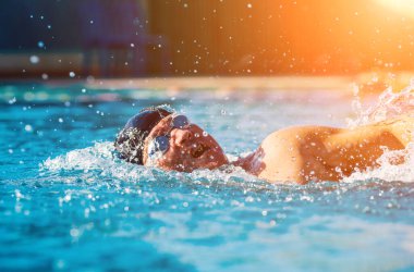 Yüzme havuzunda yüzen genç sporcu, aktif spor konsepti  