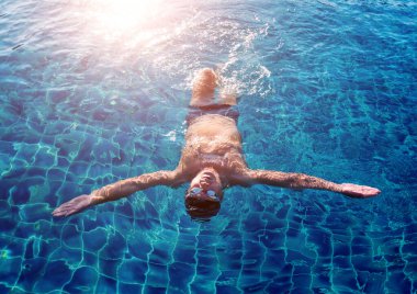 Yüzme havuzunda yüzen genç sporcu, aktif spor konsepti  