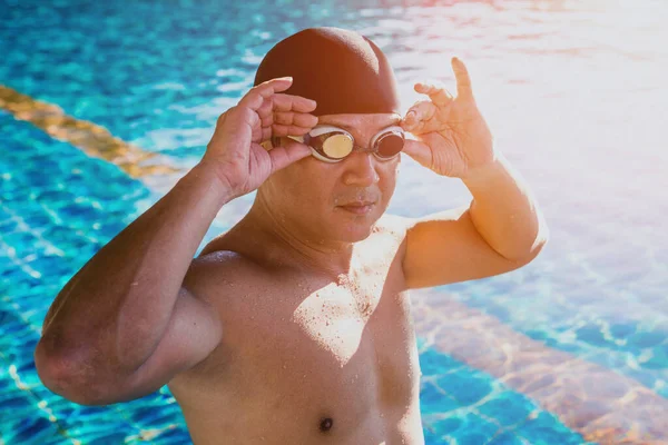 Young athletic man swimming in swimming pool, active sport concept