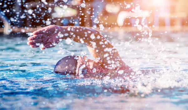 Young athletic man swimming in swimming pool, active sport concept