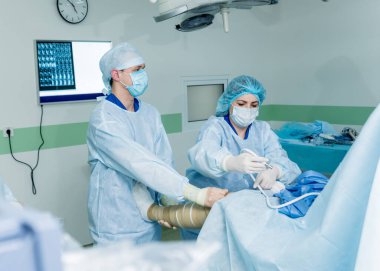 Artroskop ameliyatı. Modern artroskopik aletlerle ameliyathanede takım çalışması yapan ortopedik cerrahlar. Diz ameliyatı. Hastane geçmişi