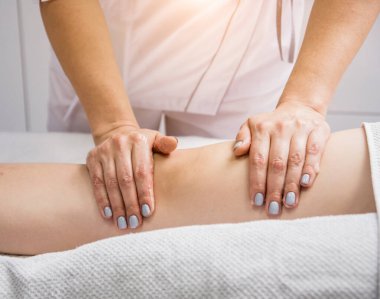 Güzeller güzeli genç bir kadın spa salonunda bacak masajı yapıyor. Kozmetoloji kavramı