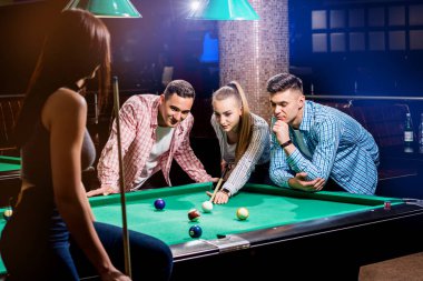 Bilardo oynayan bir grup neşeli genç arkadaş. İşten sonra eğlenceli zamanlar.