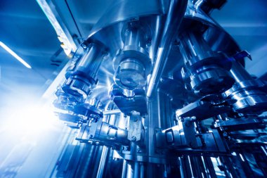 Otomatik doldurma makinesi plastik şişelere su dolduruyor, endüstriyel arka plan