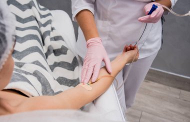 Doktor kozmetik uzmanı kozmetoloji düşürücü prosedürü uyguluyor. Enfüzyon. Güzellik salonunda genç bir kadın. Kozmetoloji kavramı.