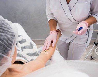Doktor kozmetik uzmanı kozmetoloji düşürücü prosedürü uyguluyor. Enfüzyon. Güzellik salonunda genç bir kadın. Kozmetoloji kavramı.