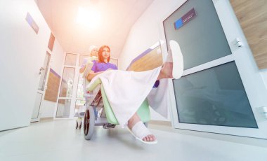 Hemşire hastanedeki hastayla seyyar tıbbi sandalyeyi hareket ettiriyor. Tıbbi ekipman. Kavram