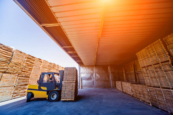 Forklift loader load lumber into a dry kiln. Wood drying in containers. Industrial concept
