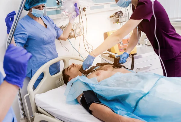 Az orvosok újraélesztenek egy férfi beteget a sürgősségin. Szívmasszázs — Stock Fotó