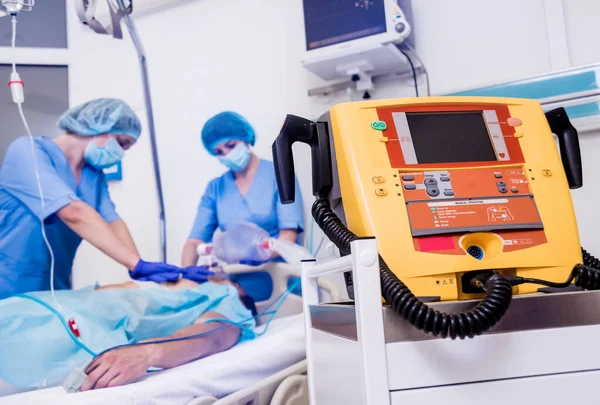 Los médicos dan reanimación a un paciente masculino en la sala de emergencias. Masaje cardíaco — Foto de Stock