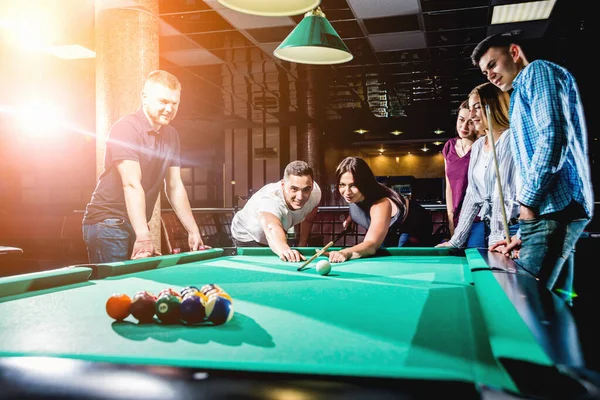 Bilardo oynayan bir grup neşeli genç arkadaş. İşten sonra eğlenceli zamanlar.