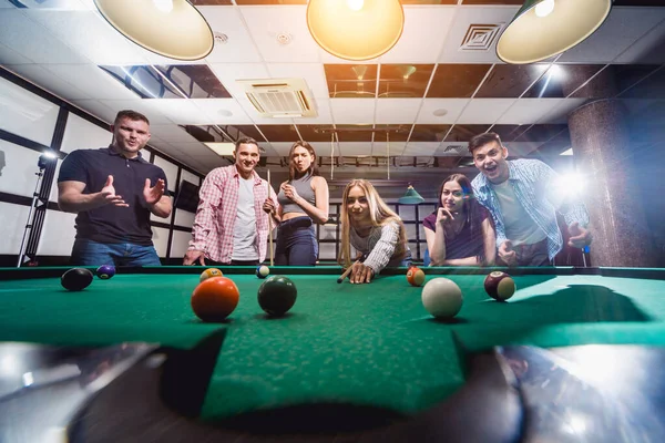 Bilardo oynayan bir grup neşeli genç arkadaş. İşten sonra eğlenceli zamanlar.