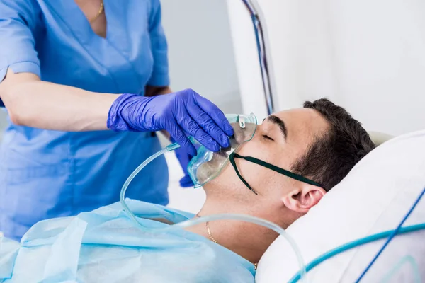 Os médicos dão reanimação a um paciente do sexo masculino na sala de emergência. Massagem cardíaca — Fotografia de Stock
