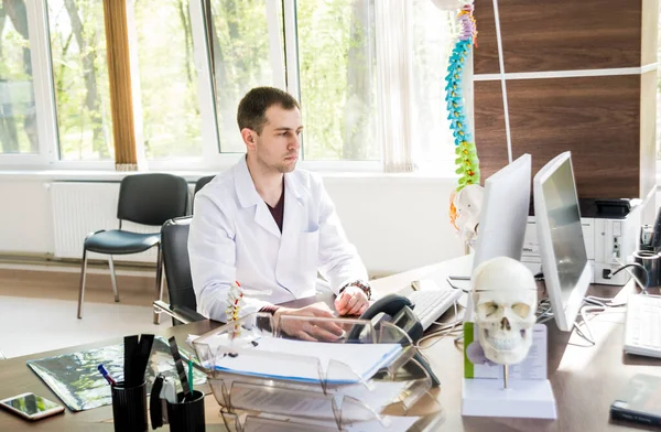 doctor working on computer at cabinet. Spinal surgery