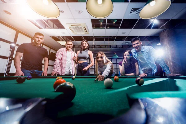 Bilardo oynayan bir grup neşeli genç arkadaş. İşten sonra eğlenceli zamanlar.