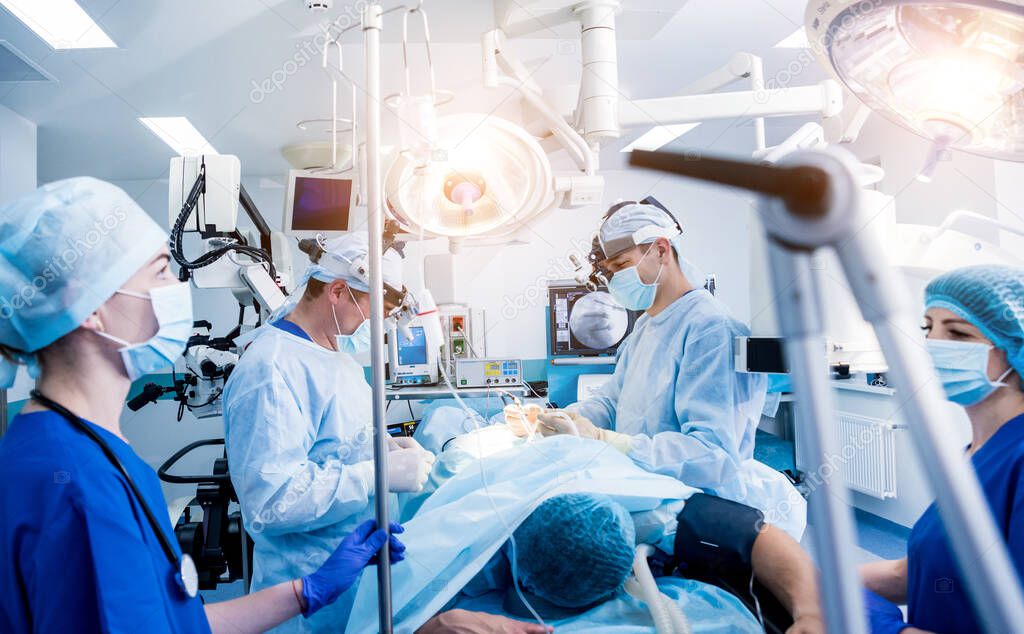 Spinal surgery. Group of surgeons in operating room with surgery equipment. Laminectomy. Modern medical background