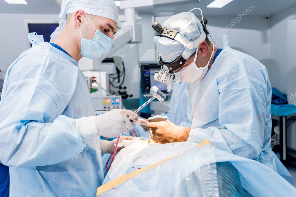 Spinal surgery. Group of surgeons in operating room with surgery equipment. Laminectomy. Modern medical background