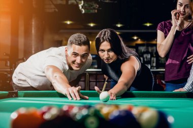 Bilardo oynayan bir grup neşeli genç arkadaş. İşten sonra eğlenceli zamanlar.